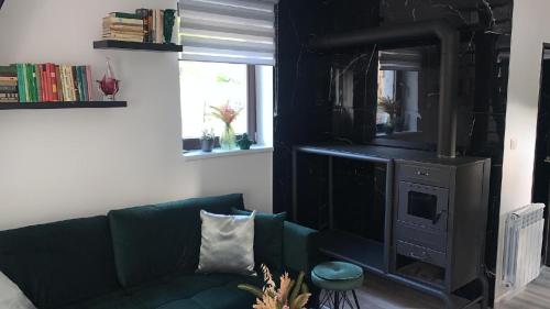 a living room with a green couch and a television at Apartman Kateřinky Liberec in Liberec