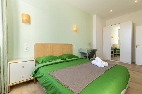 - une chambre avec un grand lit vert et des draps verts dans l'établissement Super T2 (55 m2) proche du Cours Julien, à Marseille