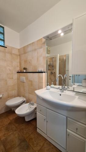 La salle de bains est pourvue d'un lavabo blanc et de toilettes. dans l'établissement LA CASA DI IA, à Vernazza