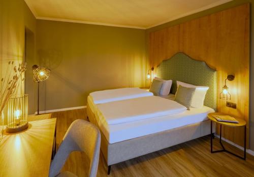 a bedroom with a large white bed in a room at Hotel Kammweg in Grossbreitenbach