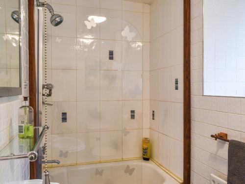 a bathroom with a shower with a tub and a sink at Beeton Cottage Todmorden in Eastwood