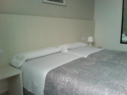 um quarto com uma grande cama branca num quarto em Estació Del Nord em Vic