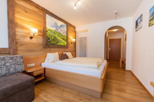 a bedroom with a bed and a couch at Pension Kristall in Schladming