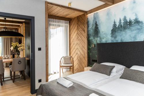1 Schlafzimmer mit einem großen Bett und einem Esszimmer in der Unterkunft Szymaszkowa 7 - luksusowe apartamenty - sauna zewnętrzna i parking w cenie in Zakopane