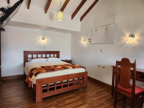 a bedroom with a bed and a desk and a chair at Hosteria de Anita in Cusco