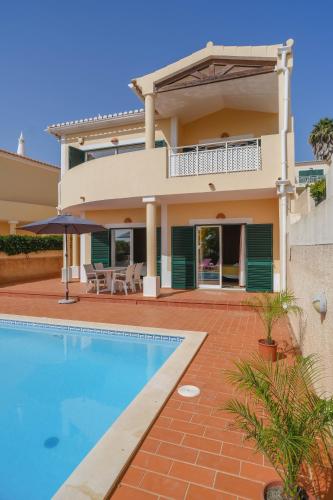 a villa with a swimming pool and a house at Vila Bela Nova Acácias 22 in Luz