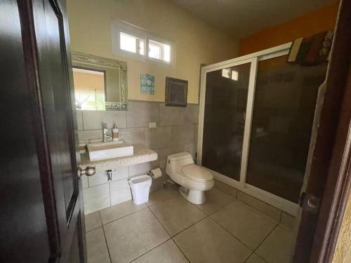 y baño con aseo, lavabo y ducha. en Casa Los Cocos Monterrico en Monterrico