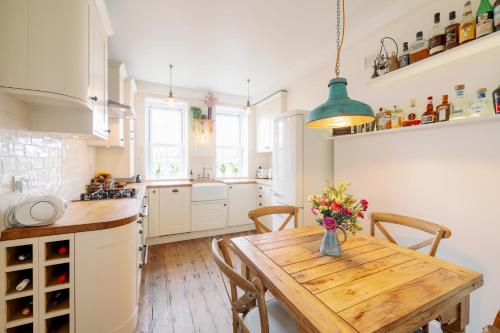 a kitchen with a wooden table with a vase of flowers at Pass the Keys Stylish Apartment in the heart of Clerkenwell in London