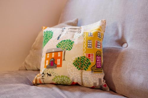 a pillow with a house on it sitting on a couch at Pass the Keys Stylish Apartment in the heart of Clerkenwell in London