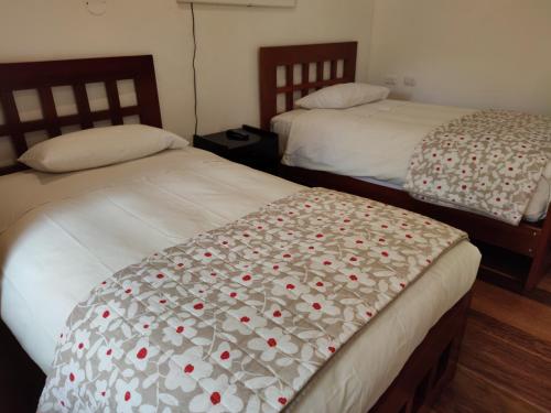 two beds sitting next to each other in a bedroom at Hosteria de Anita in Cusco