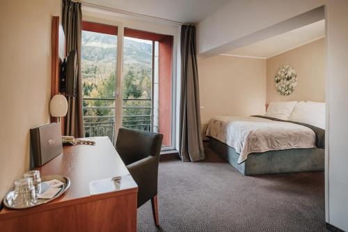 um quarto de hotel com uma cama e uma janela em Atrium Hotel - Family friendly em Nový Smokovec