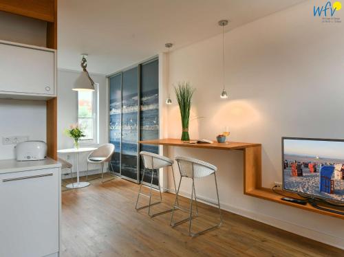 a kitchen with a table and chairs in a room at Haus Inselrose Ferienwohnung Wildrose in Juist