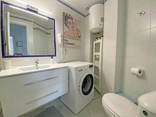 y baño blanco con lavadora. en Santa Barbara A Beach front apartment with sea view and garage in Conil, en Conil de la Frontera