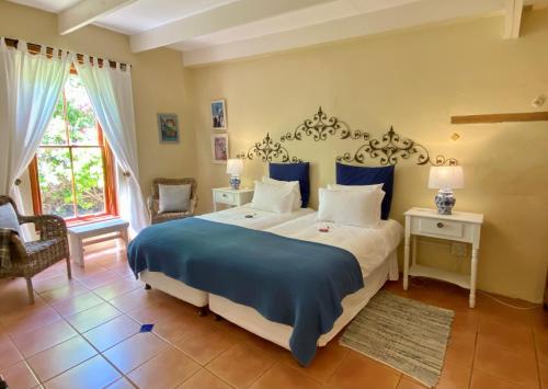 a bedroom with a large bed with blue and white sheets at Darling Lodge Guest House in Darling