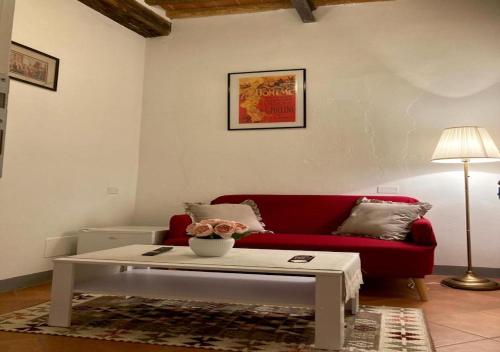 a living room with a red couch and a coffee table at B&B Giardino delle Camelie in Capannori