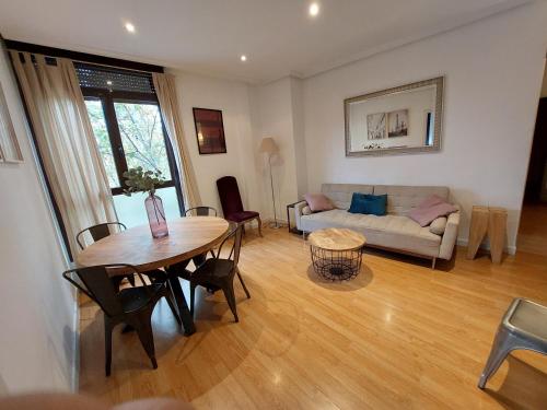 sala de estar con mesa y sofá en Apartament Glorieta Puerta de Toledo en Madrid