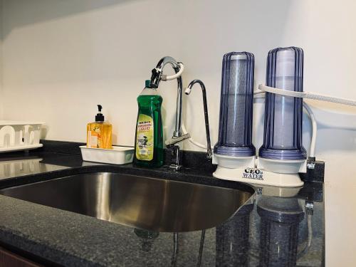 a kitchen counter with a sink and two bottles on it at The Landmark Comfort Relax Spacious Sea View By IZ in Tanjong Tokong