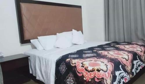 a hotel room with a bed and a desk with a bed sidx sidx at Homewood Suites Family Guest House & Apartments in Lahore