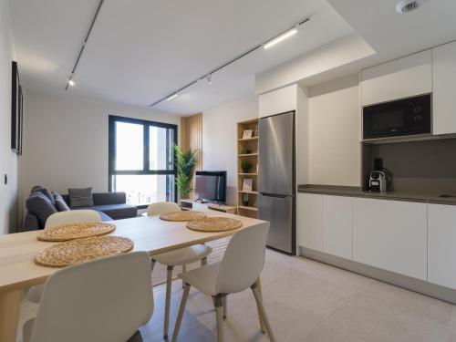 eine Küche und ein Wohnzimmer mit Tisch und Stühlen in der Unterkunft VV Arenas de Guanarteme "by henrypole home" in Las Palmas de Gran Canaria