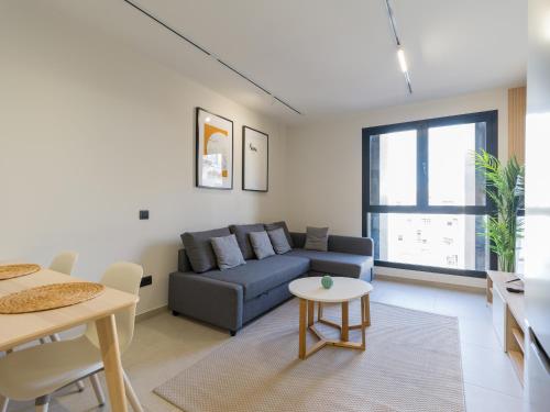 een woonkamer met een bank en een tafel bij VV Arenas de Guanarteme "by henrypole home" in Las Palmas de Gran Canaria
