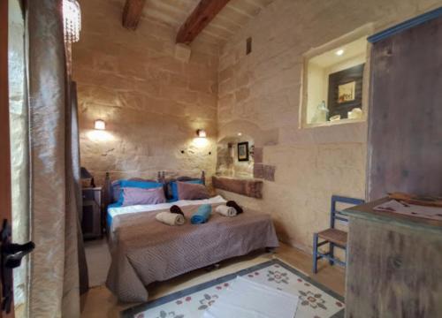 a bedroom with a bed with two pillows on it at Peaceful Farmhouse stay with cozy Yard in Għarb