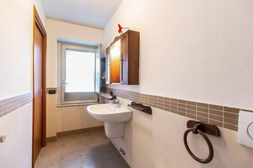 een badkamer met een wastafel en een toilet en een raam bij Alessia's Flat- Zanica in Bergamo