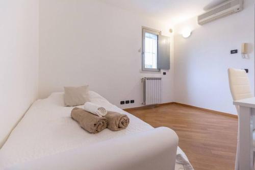 een wit bed in een witte kamer met handdoeken erop bij Alessia's Flat- Zanica in Bergamo