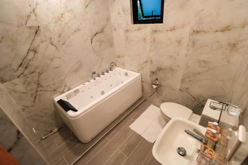 a bathroom with a tub and a toilet and a sink at Josefina's Tourist Inn in Busuanga