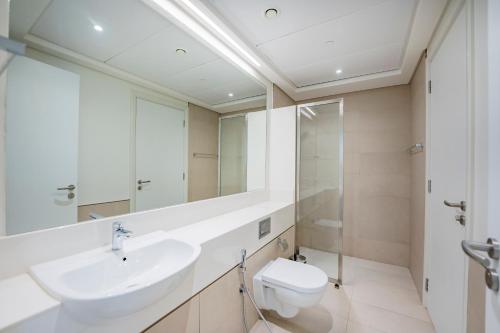 ドバイにあるExpo Village Serviced Apartmentsの洗面台、トイレ、鏡のあるバスルーム