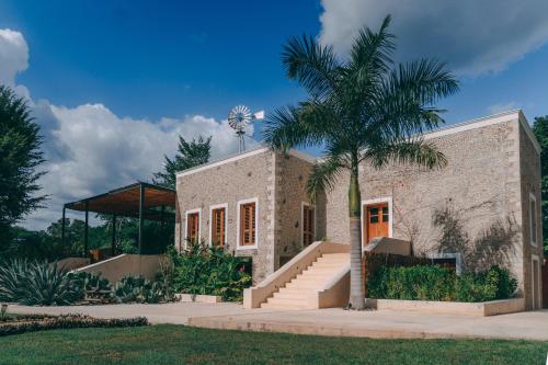 a building with a palm tree in front of it at Destino Mío Mayan Jungle Retreat in Tekit