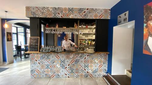 a bar with a man standing behind a counter at Hotel restaurant LA PLACE in Saint-Amand-Montrond