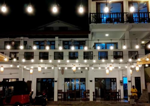 a building with lights hanging from it at night at Chill House make a Good Story with infinite Ocean Surf and Stay in Weligama