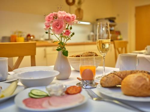 a table with a plate of food and a glass of wine at Appartement-Haus Blumenhof in Bad Griesbach