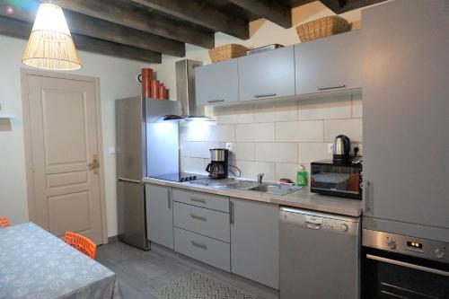 une petite cuisine avec un évier et un réfrigérateur dans l'établissement Les Gîtes du Monde , Appartements 2 chambres- 4 lits simples modulables en lits doubles, au Havre