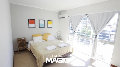 a bedroom with a bed and a large window at Departamentos 3 de Febrero in San Rafael