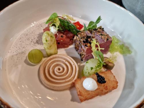 a white plate with food on a table at Hotel Abdijhof Thorn in Thorn