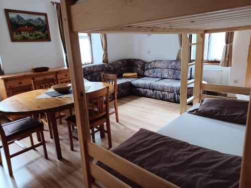 ein Schlafzimmer mit einem Etagenbett, einem Tisch und einem Sofa in der Unterkunft Groppenstein Apartmanház in Obervellach