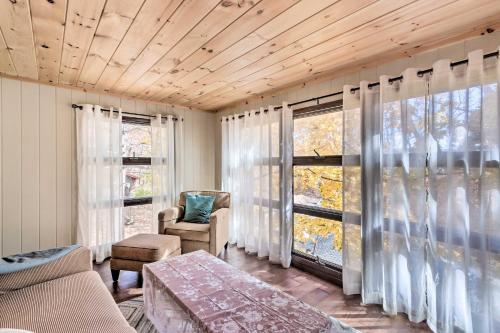 uma sala de estar com um sofá, uma mesa e janelas em Cozy Getaway Less Than 1 Mi to Cowans Gap State Park! 