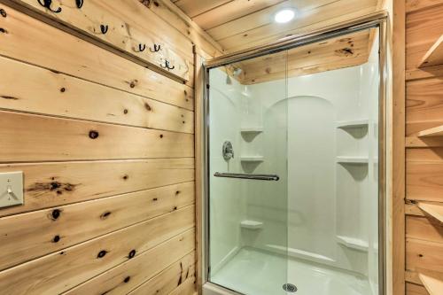 a shower with a glass door in a bathroom with wooden walls at Cozy Getaway Less Than 1 Mi to Cowans Gap State Park! 