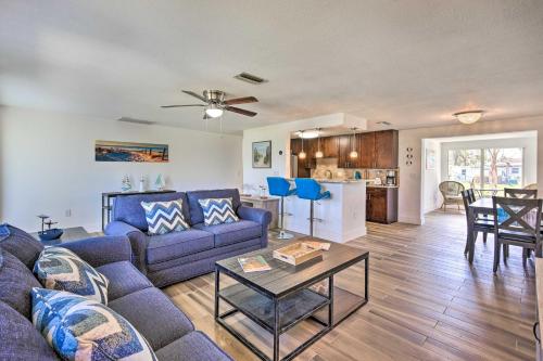a living room with a blue couch and a table at Englewood Escape with Screened-In Pool and Grill! in Englewood
