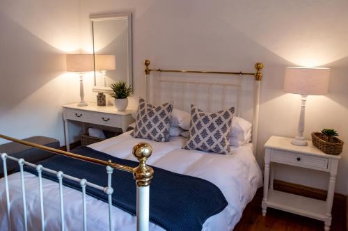 a bedroom with a bed with two night stands and a mirror at Killassy House in Graaff-Reinet