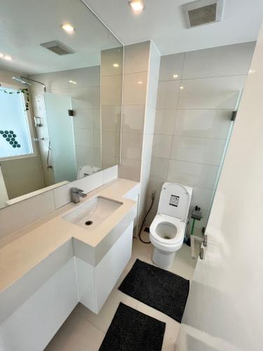 a white bathroom with a toilet and a sink at TRENDY Studio in City Center Residence in Pattaya