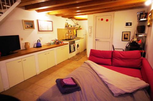 uma sala de estar com um sofá vermelho e uma cozinha em Piazzetta Santa Barbara em Bari