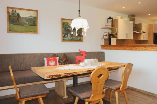 a dining room with a wooden table and chairs at Zottlhof- dein Urlaubszauber auf 1.200m in Leutasch