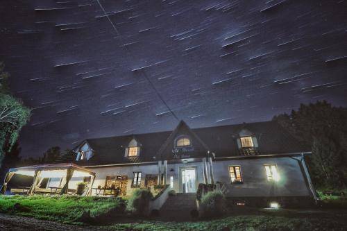 Una casa de noche con estrellas en el cielo en Pokoje Gościnne Art- Dworek, en Kudowa-Zdrój