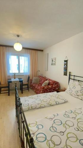 a bedroom with two beds and a living room at Grazer Spatz in Graz