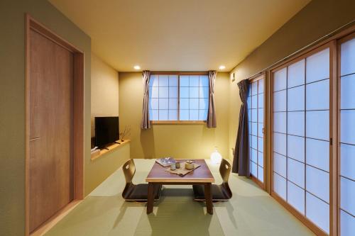 a dining room with a table and chairs and a window at Reikyo Garden Osaka in Osaka