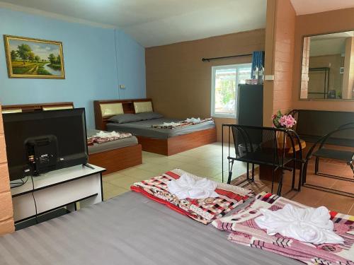 a room with a bed and a tv and a room with two beds at ทับศิลารีสอร์ท Tubsila Resort in Chongsadao