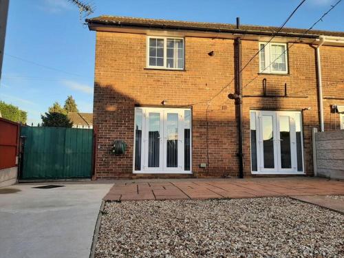 a brick house with two white doors on it at Huge Garden House for Contractors and Families in Ollerton