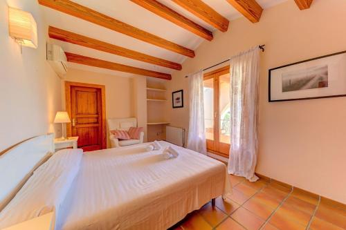 een slaapkamer met een groot bed en een raam bij Lovely Alcudia Villa Casa De Arcos Private Pool Gardens Close to Resort Centre and Beaches in Alcudia